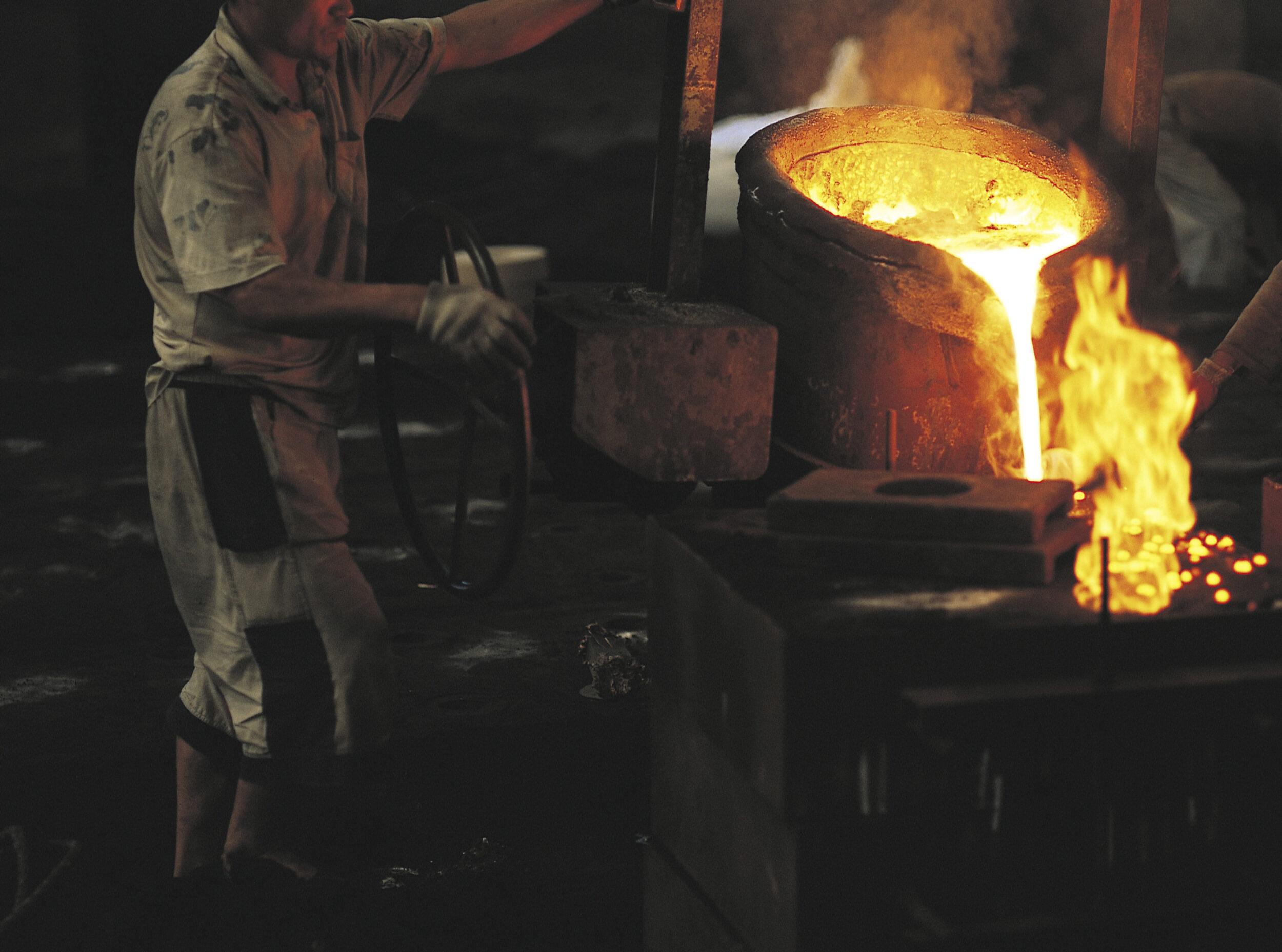Un homme verse du métal en fusion dans une fonderie